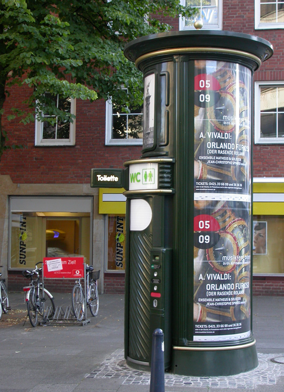 Die Werbesäule von der Seite mit Eingang zur Toilette /WC.